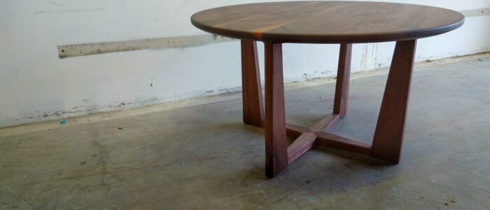 South Loft custom round wood table with a modern cross base design.